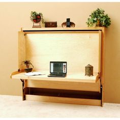 a laptop computer sitting on top of a wooden shelf next to a potted plant