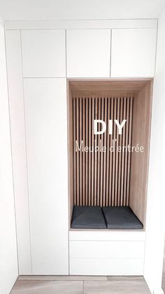 an empty room with white cabinets and black cushiones on the bench in front of it