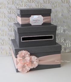 three tiered boxes with pink flowers and ribbons on the top, one is empty