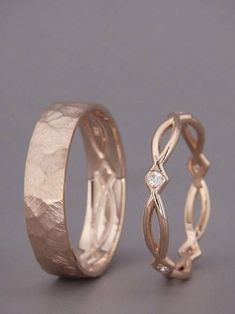 two gold wedding rings with diamond accents on each side, set against a gray background