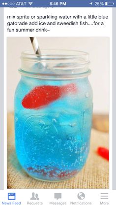 a jar filled with blue liquid and a red fish in it