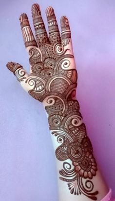 a woman's hand with henna tattoos on it