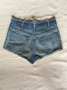 "1970s cut off jean shorts Levis 645 made in USA orange tab zip fly frayed raw waist and hem authentic age wear hem is folded up and hemmed w/fray showing label size unreadable measures, lying flat, waist-16\" rise-12\" inseam-1 hem-11\" total length-11\"" Fitted Cutoff Jean Shorts With Belt Loops, Vintage Relaxed Fit Short Leg Bottoms, Retro Distressed Bottoms For Spring, Spring Retro Distressed Bottoms, Fitted Cotton Cutoff Jean Shorts, Retro Spring Jean Shorts With Frayed Hem, Vintage Light Wash Short Jeans, Vintage Relaxed Fit Short Length Jeans, Vintage Relaxed Fit Short Jeans