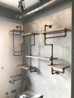 the shelves are made out of metal pipes and wooden shelves with pipe brackets on them