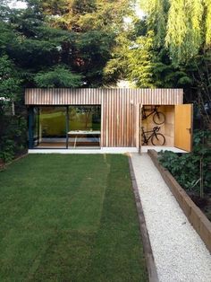 an outdoor area with grass, plants and a bike parked in the back door way