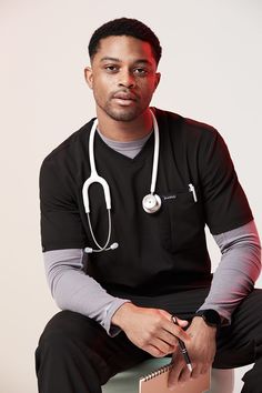 a man sitting on top of a box with a stethoscope around his neck