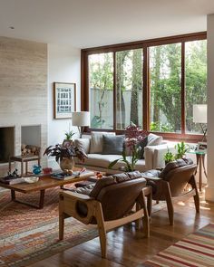 a living room filled with furniture and a fire place in front of a large window