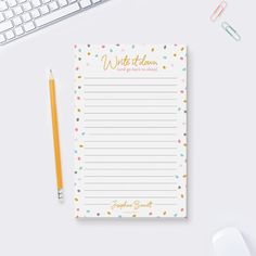 a notepad sitting on top of a desk next to a keyboard and a mouse