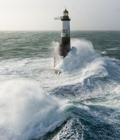 a lighthouse in the middle of some rough waves