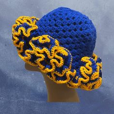 a crocheted blue and yellow hat on top of a mannequin head