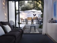 a living room with an open door leading to a patio and outdoor dining table area