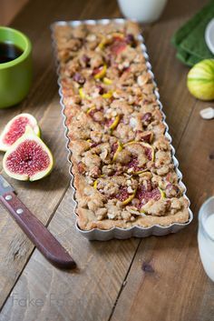 a table topped with a cake pan filled with fruit