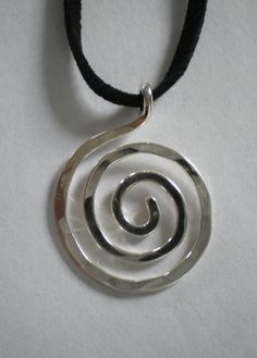 a silver spiral pendant on a black cord