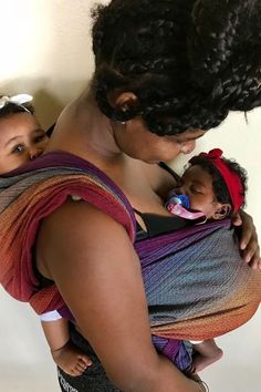 a woman holding a baby in her sling