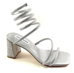 Steve Madden Lopez Silver Rhinestone Mid Heel Strappy Ankle Wrap Dress Sandal Approx. 2.75'' Heel. (Measurements are taken on small sizes ) Coil wrapping ankle tie; rhinestone detailing Embellished Front & Heel Square Toe Original $119.00 Now $109.00 Silver Tie Up Heels, Silver Heels Short Heel, Small Heels For Prom, Prom Shoes Short Heel, Silver Heels Short, Quince Shoes, Ankle Wrap Heels, Silver Glitter Heels, Formal Heels