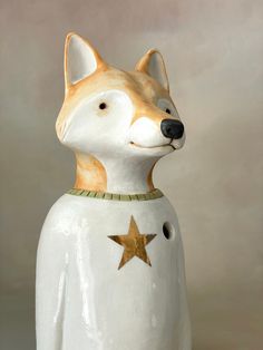 a ceramic dog with a star on it's collar is shown in front of a gray background