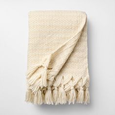 a white blanket with fringes on it