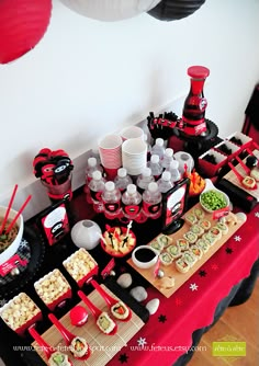 a table topped with lots of food next to a red and white balloon hanging from the ceiling