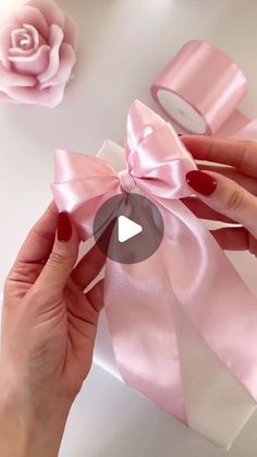 a person holding a pink bow with one hand