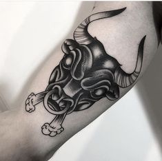 a black and white bull tattoo on the right arm with an arrow in it's mouth