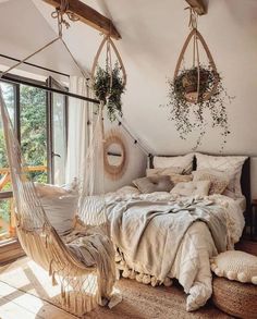 a bedroom with two hammocks hanging from the ceiling and pillows on the bed