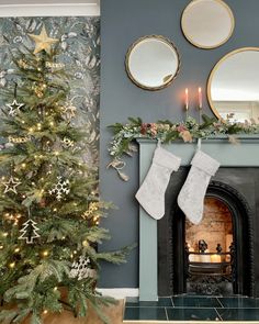 a decorated christmas tree in front of a fireplace