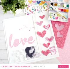 an open scrapbook with paper hearts on it