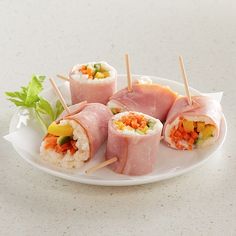 several sushi rolls on a plate with toothpicks and garnishes