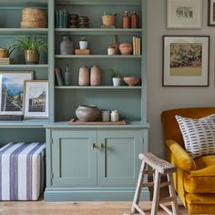 a living room filled with lots of furniture and pictures on the wall next to bookshelves