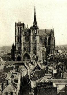 an old black and white photo of a cathedral in the middle of a large city