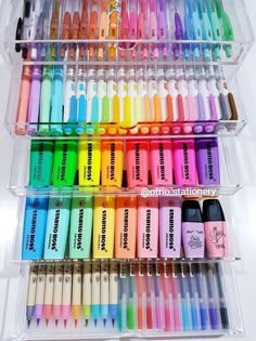 a plastic container filled with lots of different colored markers and pens on top of each other