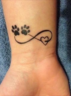 a dog paw and heart tattoo on the wrist