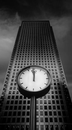 a large clock in front of a tall building