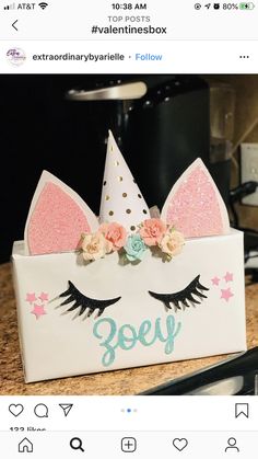 a white box with pink and blue flowers on it that has a unicorn's ears