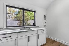 an empty kitchen with white cabinets and stainless steel counter tops is seen in this image