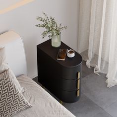 a vase with flowers on top of a black cabinet next to a white bed and pillows