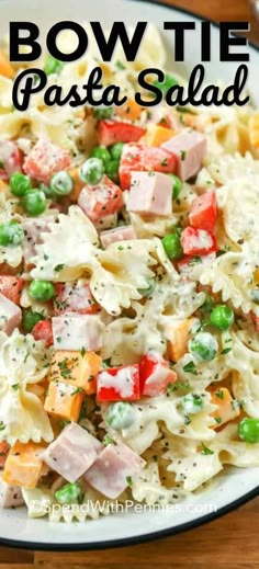 bow tie pasta salad with peas and ham in a white bowl on a wooden table