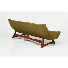 a green couch sitting on top of a wooden stand