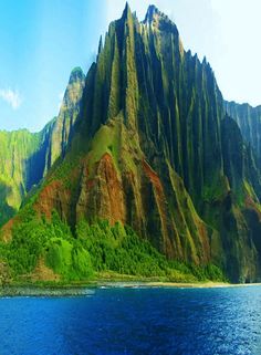 the mountains are very tall and have green trees on them, along with blue water