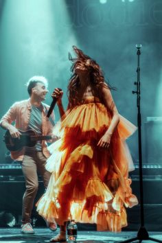 a man and woman are performing on stage