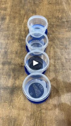 three plastic containers sitting on top of a wooden table