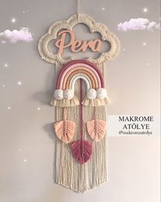 a decorative wall hanging with a rainbow and clouds on it's side that says pera