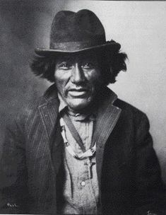 an old black and white photo of a man wearing a hat