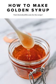 a spoon is pouring honey into a jar