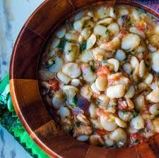 a wooden bowl filled with beans and vegetables