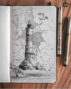 an open notebook with a drawing of a lighthouse