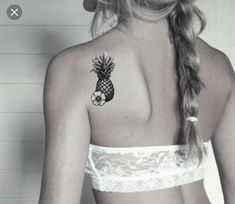 a woman with a pineapple tattoo on her back shoulder and arm, wearing a bra