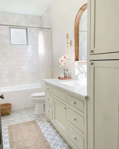 a bathroom with white cabinets and tile flooring