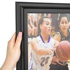 a woman holding a basketball in front of her face