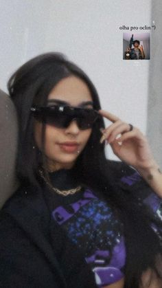 a woman wearing sunglasses is posing for the camera with her hand on her head and she has long dark hair